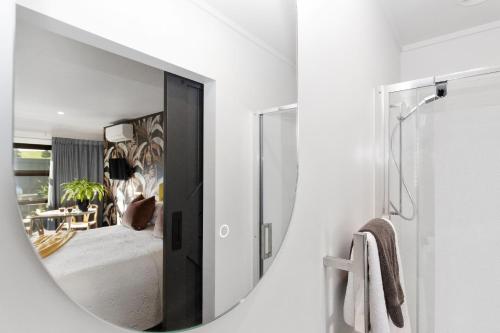 een spiegel in een badkamer met een slaapkamer bij Matamata Lodge in Matamata