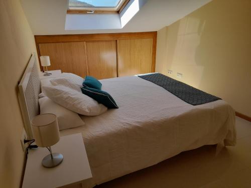 1 dormitorio con 1 cama grande y ventana en Margaritas, en Finisterre
