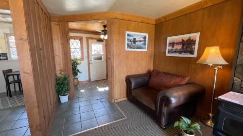 ein Wohnzimmer mit einem Ledersessel und einer Lampe in der Unterkunft Yosemite Gateway Motel in Lee Vining