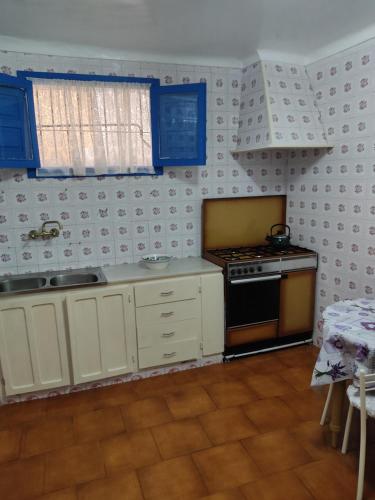 a kitchen with white cabinets and a stove top oven at Casa de la abuela Tere Caminito del Rey, Valle de Abdalajís, Málaga in Valle de Abdalagís