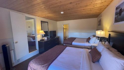 ein Hotelzimmer mit 2 Betten und einem Spiegel in der Unterkunft Yosemite Gateway Motel in Lee Vining