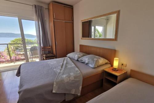 a bedroom with a bed and a window with a view at Apartments by the sea Zivogosce - Mala Duba, Makarska - 18626 in Igrane