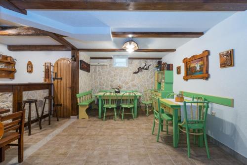 uma sala de jantar com mesas e cadeiras verdes em Apartments by the sea Vir - 18603 em Vir