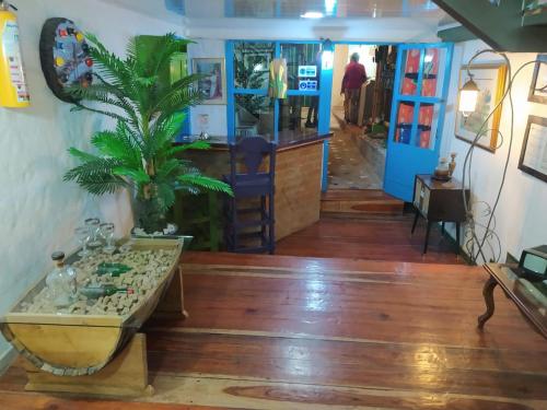 a room with a table and a palm tree in it at Hostel Camelot Salento in Salento