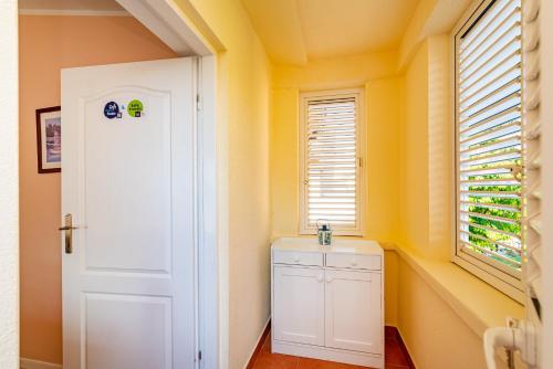 ein Badezimmer mit gelben Wänden und einer weißen Tür in der Unterkunft Apartments by the sea Privlaka, Zadar - 18652 in Privlaka