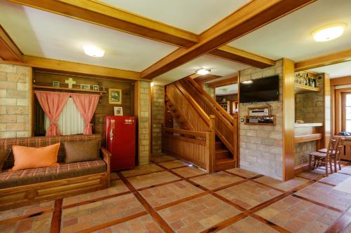 uma sala de estar com um sofá e um frigorífico vermelho em Mountain Villa Udovicic em Zlatibor