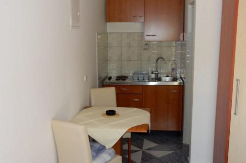 a small kitchen with a table and a sink at Apartments by the sea Loviste, Peljesac - 18656 in Lovište