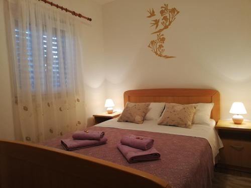 1 dormitorio con 1 cama con 2 toallas en Apartments with a parking space Punta kriza, Cres - 18644, en Nerezine