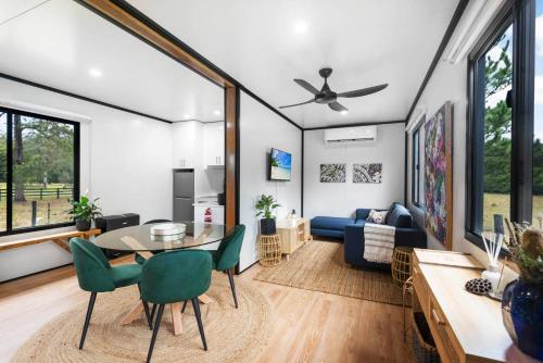 a living room with a table and green chairs at Contained in Nimbin Accommodation in Nimbin