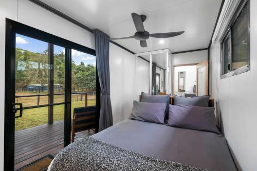 a bedroom with a bed and a large window at Contained in Nimbin Accommodation in Nimbin