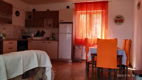 a kitchen with a table and chairs and a refrigerator at Apartments by the sea Necujam, Solta - 18664 in Grohote