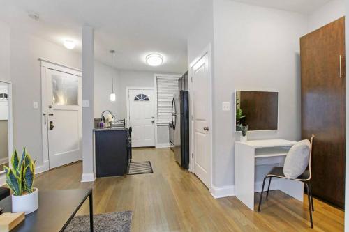 a living room with a desk and a kitchen at Stylish Studio Apartment in Portage Park - Pensacola 2N in Chicago