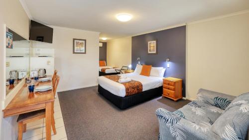 pokój hotelowy z łóżkiem i kanapą w obiekcie Best Western Caboolture Gateway Motel w mieście Caboolture