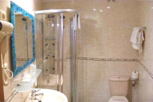 a bathroom with a shower and a toilet and a sink at Hotel Chipén in Vigo