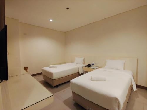 a hotel room with two beds and a television at Kaizen Suites in Manila