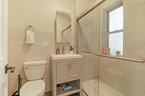 uma casa de banho com um WC, um lavatório e um chuveiro em Modern Minimalist Studio Apt in Portage Park - Pensacola 3W em Chicago