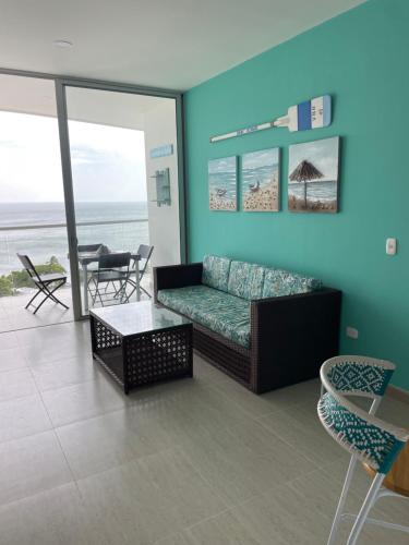 a living room with a couch and a view of the ocean at Espectacular Apartamento Sierra Beach Resort in Santa Marta