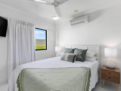 a white bedroom with a bed and a window at 3 BEDROOM CBD WATERFRONT LUXURY APARTMENT in Cairns