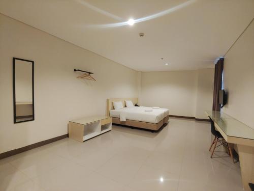 a bedroom with a bed and a mirror and a desk at Kaizen Suites in Manila