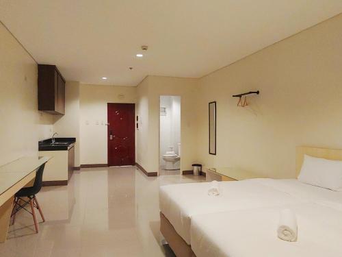 a hotel room with a bed and a kitchen at Kaizen Suites in Manila