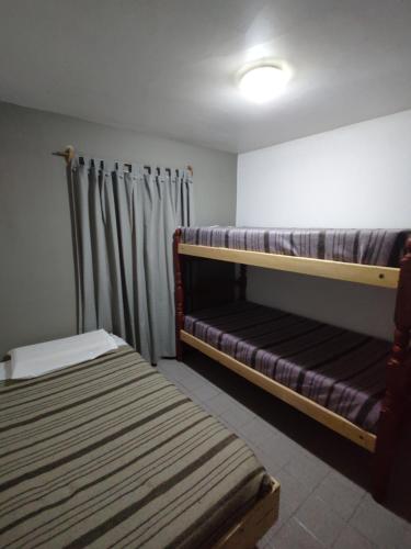 a room with two bunk beds and a curtain at Shaddai alojamientos in Salta