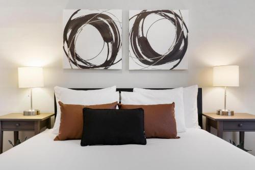 1 dormitorio con 1 cama blanca y 2 lámparas en 1BR Simple & Roomy Apartment in Evanston - Hinman S3, en Evanston
