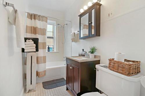 y baño con lavabo, aseo y bañera. en 1BR Simple & Roomy Apartment in Evanston - Hinman S3, en Evanston