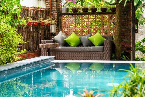 a garden with a couch and a swimming pool at Olala An Bang Villa in An Bang