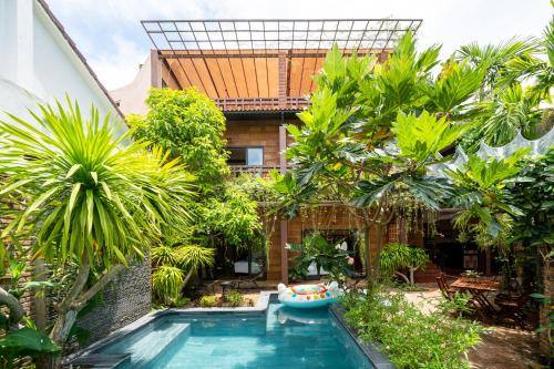 een zwembad voor een huis met bomen bij Olala An Bang Villa in An Bàn (2)