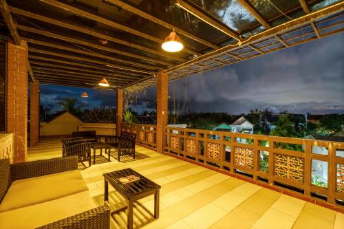 a patio with a table and chairs on a deck at Olala An Bang Villa in An Bang