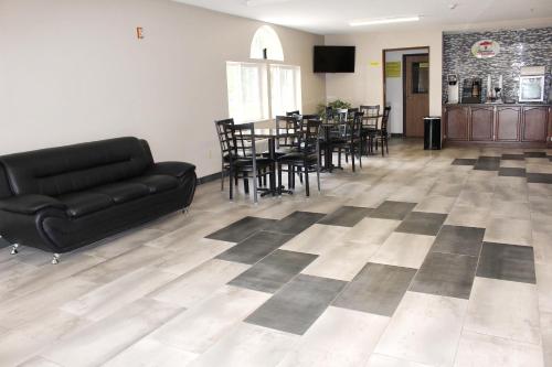 a living room with a couch and a table and chairs at Super 8 by Wyndham De Soto in De Soto