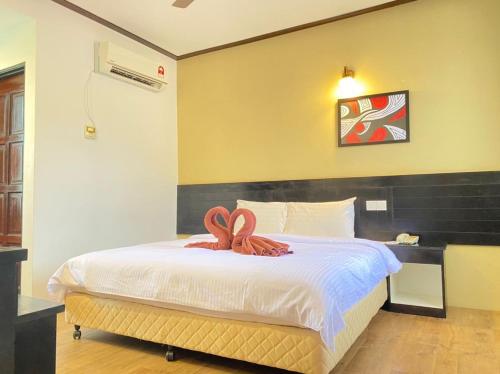 Un dormitorio con una cama con dos serpientes. en Anjung Villa, en Pantai Cenang
