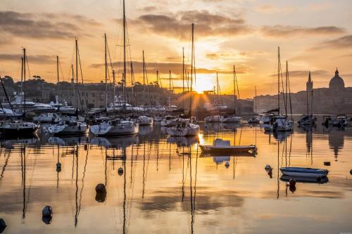 a group of boats in a marina at sunset at Luxurious 2BR Apartment in Valletta in Valletta