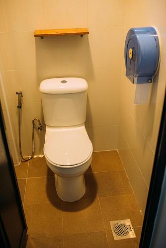 a toilet in a bathroom with a toilet paper dispenser at Bluewaters Pods 38 Hongkong St in Singapore