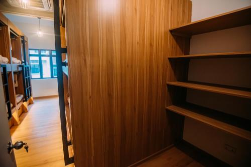 a room with wooden walls and a door with a television at Bluewaters Pods 38 Hongkong St in Singapore