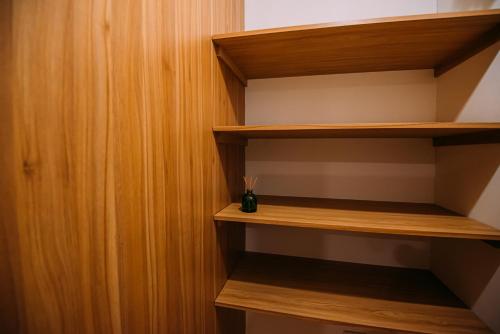 a closet with wooden shelves and a vase in it at Bluewaters Pods 38 Hongkong St in Singapore