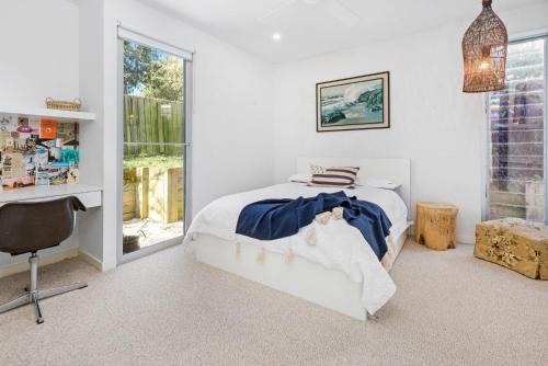 a bedroom with a bed and a desk and a window at Poolside Paradise Mount Eliza in Mount Eliza