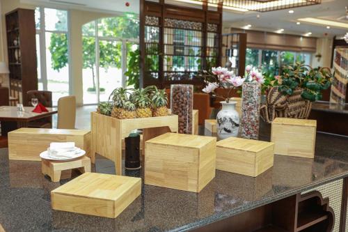 Un vestíbulo con taburetes de madera y plantas en un mostrador. en Ninh Binh Legend Hotel, en Ninh Binh