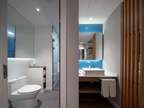 uma casa de banho com um WC branco e um lavatório. em Holiday Inn Express Shanghai Qingpu New City, an IHG Hotel em Xangai