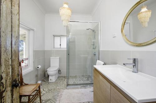 a bathroom with a shower and a toilet and a sink at Woolway in Bilpin