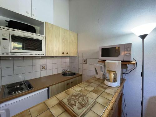- une cuisine avec un comptoir, un four micro-ondes et une cafetière dans l'établissement Appartement 2 pièces cabine à 700m du village - Praz-Sur-Arly - 6 pers - Ski et lac prox. - FR-1-603-61, à Praz-sur-Arly
