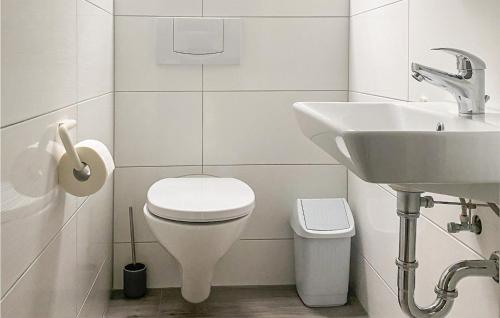 La salle de bains blanche est pourvue de toilettes et d'un lavabo. dans l'établissement Ferienhaus 39 In Kirchheim, à Kirchheim