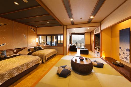 a bedroom with two beds and a living room at Kanazawa Hyakurakusou in Kanazawa