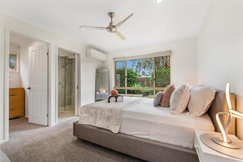 a white bedroom with a large bed and a window at Maroochy Magic Family Coastal Getaway in Maroochydore