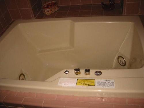 a bath tub in a bathroom with a sign on it at Ocean's Breeze, 4/bed, 3/ba, Game Room. Sleeps 10! in Morro Bay