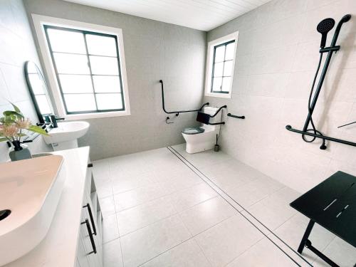 a white bathroom with a toilet and a sink at Seven Peaks Farm Stay in Beerwah