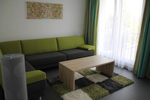 a living room with a green couch and a coffee table at Gästehaus Wilhelmshöhe in Butzbach