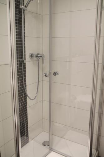 a shower with a glass door in a bathroom at Gästehaus Wilhelmshöhe in Butzbach