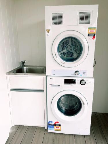 a washer and dryer in a kitchen with a sink at Seven Peaks Farm Stay in Beerwah