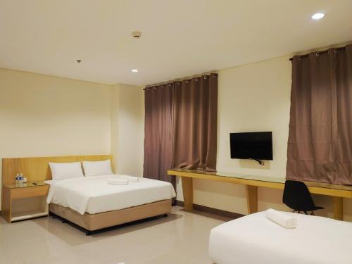 a hotel room with two beds and a television at Kaizen Suites in Manila